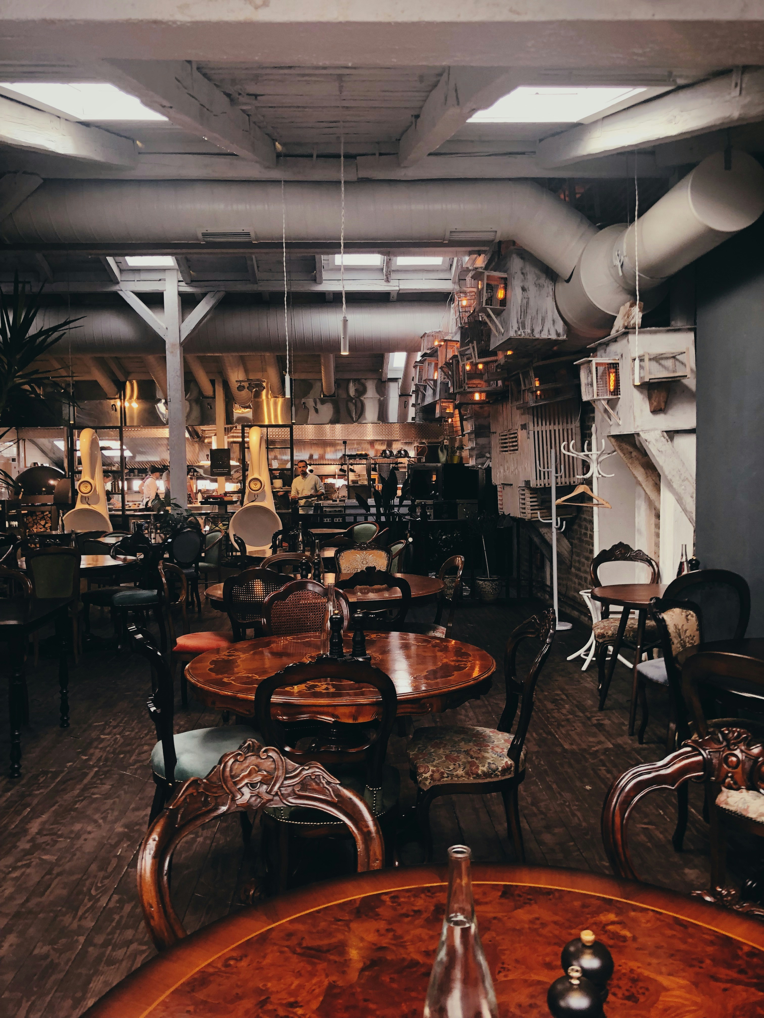 A dimly lit restaurant with wooden tables and old-fashioned chairs.